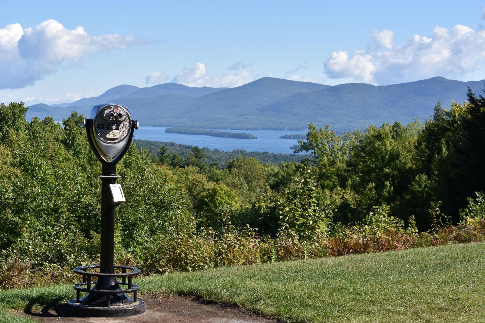 A metal pole with a view of a lake and mountains.